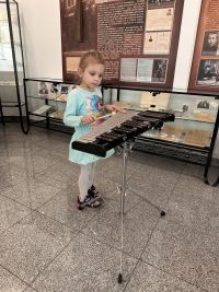 Dziecko w Izbie Pamięci Rodziny Maklakiewiczów grające na instrumencie